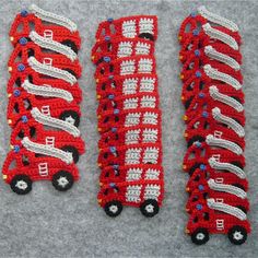 three pieces of crocheted red and white train broochies on grey background