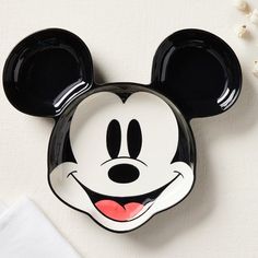 a mickey mouse face plate sitting on top of a table next to a white napkin