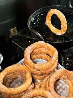 some onion rings are sitting on top of a grill with other food items around them