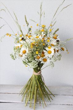 a bouquet of daisies and wildflowers in a vase