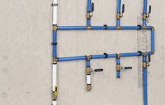 several blue pipes connected to each other on a wall with white and yellow piping