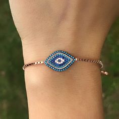 "This Evil Eye Adjustable Bracelet with a evil eye charm is micron plated in 18K Rose Gold for a lasting finish and to ensure its hypoallergenic. Dainty bracelets make the perfect gift! Tarnish Resistant. Bracelet for women A style made for whatever's on your schedule that day. Pair it with your favorite cocktail dress or a casual pair of jeans - either way, this bracelet is sure to shine. Gift Box & Jewelry Bag: Your Somje Jewelry will arrive pre-packaged in a genuine branded gift box and jewelry bag. This bracelet makes a perfect gift for Valentine's Day, Christmas, your wedding anniversary, Mother's Day and birthdays. Quality: Solid Sterling Silver. Micron 18K Yellow Gold plating over Sterling Silver to prevent tarnishing. High quality finish gives it the elegance of any fine jewelry. C Rose Gold Evil Eye Bracelet As Gift, Evil Eye Metal Bracelet Gift, Gift Metal Evil Eye Round Bracelet, Adjustable Rose Gold Evil Eye Bracelet, Evil Eye Bracelet Gold, Adjustable Blue Evil Eye Bracelet Hand-strung, Affordable Adjustable Hand-strung Evil Eye Bracelet, Kabbalah Bracelet, Adjustable Nickel-free Blue Evil Eye Bracelet