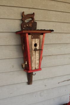 an old birdhouse is hanging on the side of a house