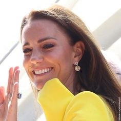 a close up of a person with a smile on her face and hands in the air