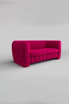 a pink couch sitting on top of a gray floor