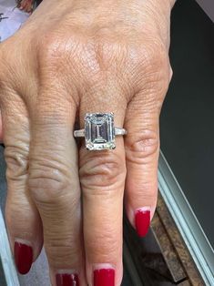 a woman's hand with a ring on it and a diamond in the middle