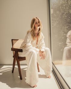 a woman sitting on a chair in front of a window