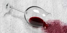 a wine glass filled with red liquid sitting on top of a white carpeted floor