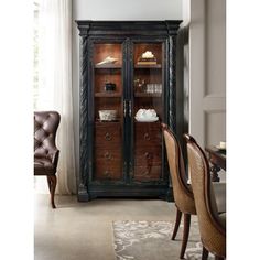 an armoire in a living room with chairs