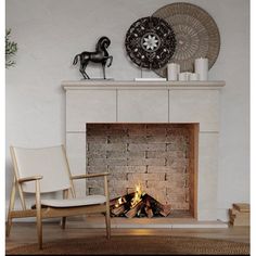 a living room with a fire place next to a rocking chair and horse figurine