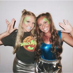 two young women posing for the camera with their hands in the air and painted green