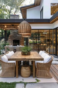 an outdoor dining area with wicker chairs and a wooden table surrounded by white cushions