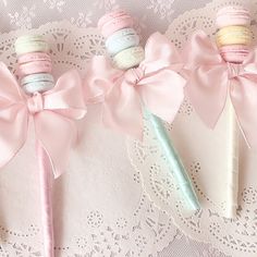 three macaroons wrapped in pink ribbon and tied with bows on top of doily