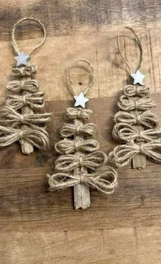 three small christmas trees made out of twine on a wooden board with star decorations