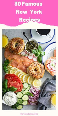 a plate with bagels, tomatoes, cucumbers and other food on it