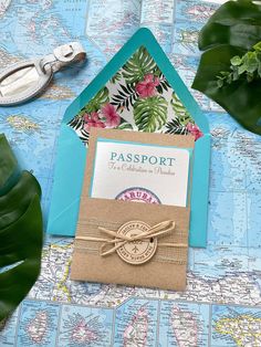 an open passport card on top of a map next to a pair of scissors and some plants