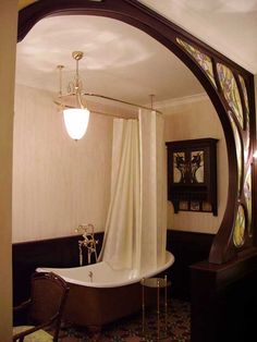 a bathroom with a bathtub, chandelier and window in it's corner