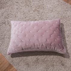 a pink pillow laying on the floor