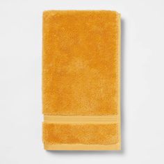 a yellow towel on a white surface with the word,'hotel towels'written in gold