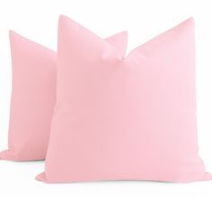 two pink pillows sitting next to each other