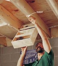 a man is working on the ceiling in his garage with wood planks attached to it