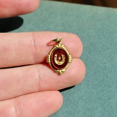 This charm is made of an 10x8mm carved glass cab that was produced in Germany in the 1970s.The charm has been hand set in a raw brass setting. The overall size of the charm including the setting is 18mm tall (including loop) and 12mm wide.The charm comes with a jump ring for threading on your favorite necklace or jewelry making.There may be very minor variances in stone detailing due to vintage nature of the item. Antique Brass Charms For Collectors, Vintage Engraved Brass Charms, Vintage Engraved Jewelry For Good Luck, Vintage Brass Jewelry For Good Luck, Vintage Handmade Brass Charms, Handmade Vintage Brass Charms, Vintage Gold Horseshoe Jewelry, Brass Vintage Charm For Collectibles, Vintage Nickel Free Brass Charms