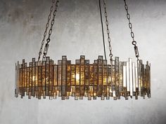 a chandelier made out of glass blocks hanging from chains on a wall in a room