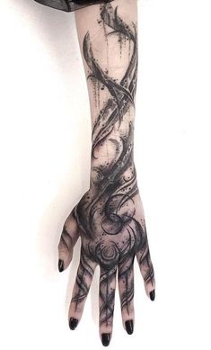 a person's hand with black ink on it and an intricate design in the middle