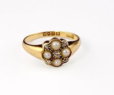 a close up of a ring with pearls on it's side and an inscription in the middle