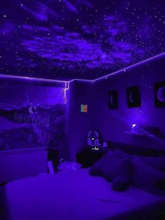 a bed room with a purple glow in the ceiling and some pictures on the wall