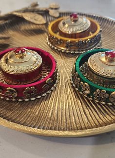 three different types of jewelry on a gold plate with red and green trimmings