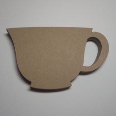 a paper cut out of a coffee cup on a white surface with a hole in the middle