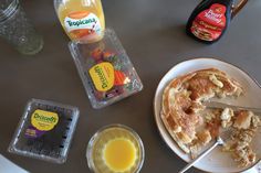 a table topped with breakfast foods and juice