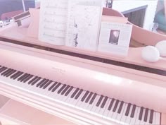 a pink piano with sheet music and an egg sitting on it's top shelf