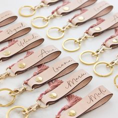 pink and gold keychains with name tags attached to each other on a table