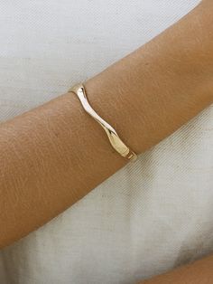 PLEASE NOTE: THIS STYLE IS ON PRE-ORDER AND WILL BE SHIPPED ON THE 6TH JANUARY. Our best-selling Rae Bangle features an organic wave design in a gold bangle. Designed in Sydney, handcrafted and delivered in Love Isabelle Jewellery custom gift boxes. Item Details: 14k Gold Filled Wave design 58mm x 50mm diamater As we operate as a waste-efficient business, if you are purchasing more than one item, and require individual boxes for your jewellery, please add your requests in your order notes or ema Modern Twist Bangle As Gift, Modern Jewelry For Anniversary, Modern Twist Yellow Gold Bracelet For Gift, Modern Wavy Jewelry For Anniversary, Modern Wavy Jewelry For Formal Occasions, Modern Twist Hammered Jewelry As Gift, Hammered Bracelets For Anniversary, Hammered Jewelry With A Modern Twist As A Gift, Wavy Yellow Gold Jewelry For Formal Occasions