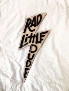 two wooden magnets with the words rad little rock written on them in black