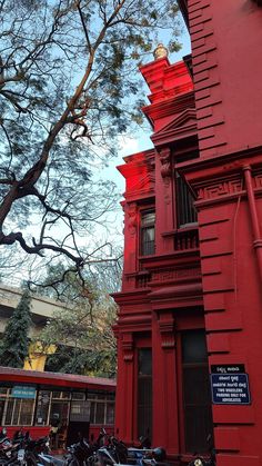 a tall red building sitting next to a group of parked motorcycles in front of it