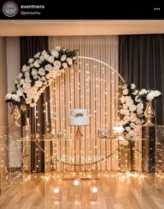 a white wedding cake sitting on top of a table next to candles and flowers in vases