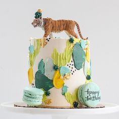 a birthday cake with a tiger figurine on top