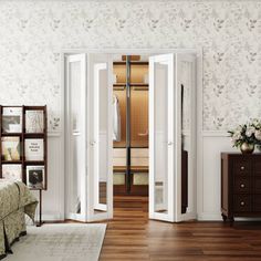 an open door leading into a bedroom with white walls and wood flooring on the side