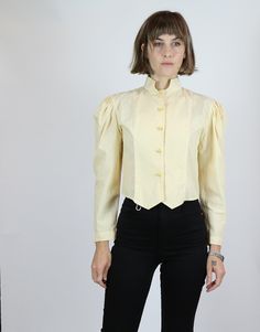 "Women's Vintage Renato Nucci Blouse  | Made In France | Cotton | PARIS EDIT *Paris Edit*  This item was hand selected by me in Paris during May 2023! I hope you love them as much as I do <3  Description Stunning utilitarian/Victorian French blouse. Yellow candy stripe with gorgeous knotted buttons. Slightly puffed shoulder with tab tuck at centre back to cinch waist.  Material - 100% Cotton Brand - Renato Nucci Size -  Not labelled, will suit a size XS - Small based on below measurements Measurements lying flat Waist - 40.5cm  Bust - 44cm  Length - 52cm  Hem - 40cm Sleeve Length - 58cm (from shoulder) Model usually wears size 6-8 and measures Waist - 62cm Hips - 82cm Bust - 86cm Height - 5\"7\" This is a vintage item sourced from France and inspected in Melbourne, Australia. Items have be Yellow Fitted Shirt For Fall, Fitted Yellow Shirt For Fall, Elegant Yellow Tops For Daywear, Fitted Shirt For Fall Daywear, Elegant Fitted Yellow Tops, Elegant Yellow Fitted Top, Fitted Fall Shirt For Daywear, Chic Fitted Yellow Shirt, Chic Yellow Fitted Shirt