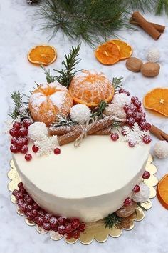 a white cake topped with oranges and cranberries on top of a table