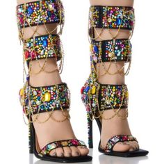 Destined To Be A Pop Culture Icon In The Azalea Wang " Layers Of London " Multi Embellished Sandal! Crafted Using A Satin Textile Upper, These Ornate Sandals Feature An Open Squared Toe Silhouette, A Mid-Calf Shaft Height, A Contrast Metallic Faux Leather Cushioned Insole, A Gemstone Embellished Slim Stiletto Heel, A Gladiator-Style Strappy Design, And A Slim Gemstone Embellished Toe Band. Complete With Colorful, Clustered Gem-Detailing And Cascading Rhinestone Link Accents Adorning The Shaft, A Multicolor Open Toe Heels For Party, Multicolor Block Heel Sandals For Party, Multicolor Embellished Open Toe Heels, Multicolor High Heel Sandals With Rhinestones, Multicolor Rhinestone High Heel Sandals, Bedazzled Sandals For Spring Party, Multicolor Rhinestone Sandals For Spring, Glamorous Multicolor Rhinestone Heels, Glamorous Multicolor Evening Heels