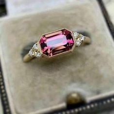 a pink tourmaline and diamond ring in a box