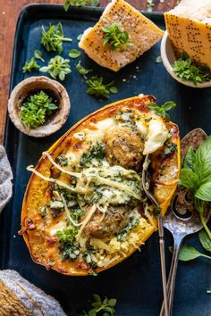 baked spaghetti dish with spinach and parmesan cheese on a blue serving tray