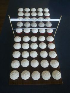 cupcakes with white frosting are arranged on a black surface and lined up in rows