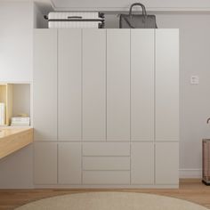 a room with white cabinets and a rug on the floor in front of a window