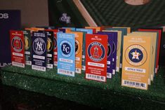 a row of baseball cards sitting on top of a green field next to a wall