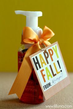 an orange ribbon is tied around a bottle of soap with a happy fall tag on it